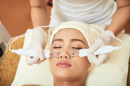 Close-up shot of attractive Asian woman having needle free mesotherapy while spending day at modern...