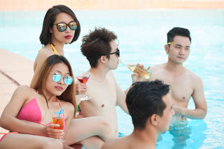 Young Asian people spending summer day by the poolの写真素材