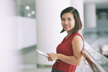 Portrait of beautiful young female business executive with tablet computerの写真素材