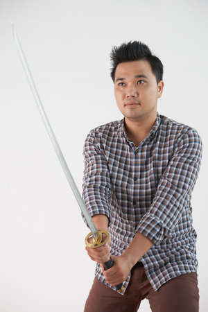 Vietnamese young man with katana sword, isolated on whiteの写真素材