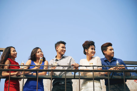 Five smiling happy people holding champagne glass at a party