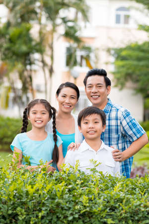 Portrait of Asian family of four standing outdoorsの写真素材