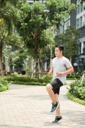 Active handsome young man running in the streetの写真素材