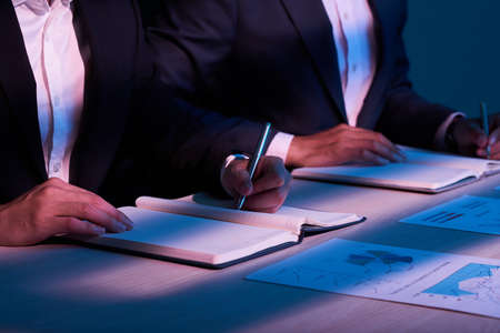 Businessman analyzing financial chart and taking notesの写真素材