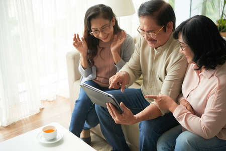 Senior people with touchpad spending time togetherの写真素材