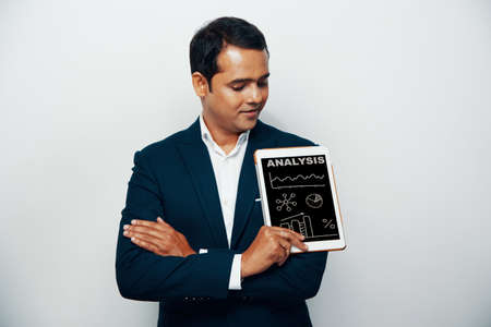 Confident businessman holding tablet with business analytics on screenの写真素材