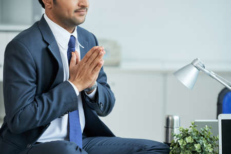 Close-up of businessman meditating on his workplace at officeの写真素材