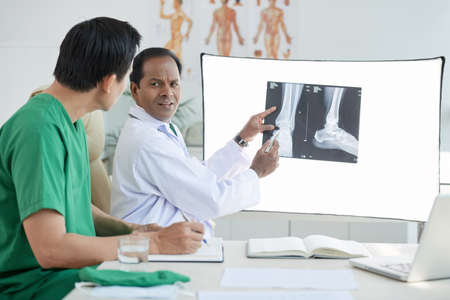 Two doctors looking at x-ray scan at doctor's officeの写真素材