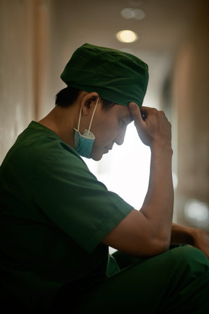 Upset surgeon sitting alone after she failed an operation