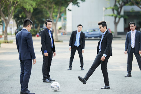 Businessmen playing footballの写真素材