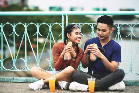 Couple enjoying juice and sanwiches