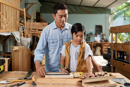 Father and son in workshopの写真素材