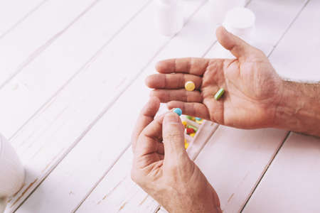 Aged man taking pillsの写真素材