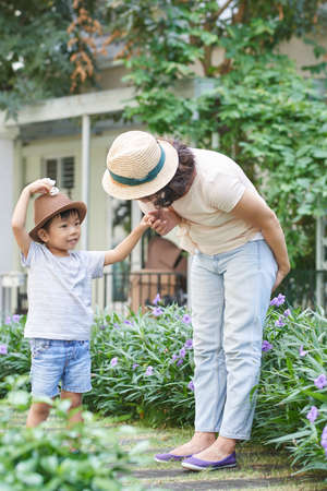 Mother asking her little son question when they are walking in parkの写真素材