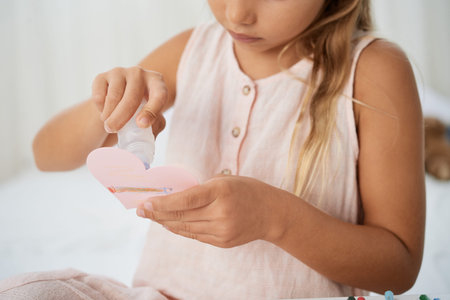 Little girl creating greeting card for mothers day
