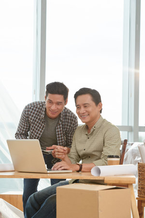 Smiling coworkers searching online for office to rent