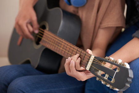 Crop view of couple in casual clothes sitting together, female holding acoustic guitar and male...