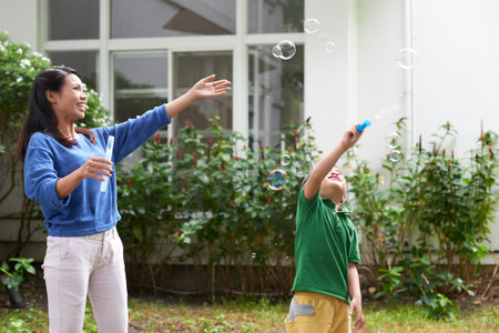 Mother and son blowing soap bubbles