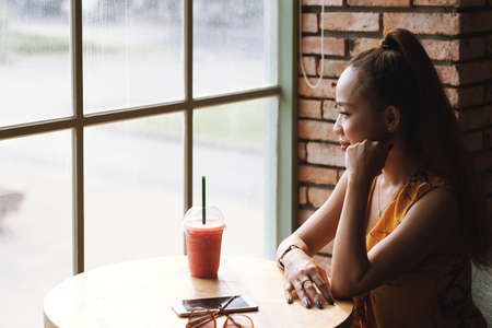 Contemplating woman in cafeの写真素材