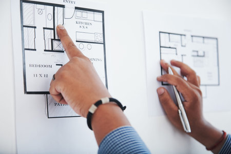 Engineer pointing at bathroom on apartment blueprint, selective focus