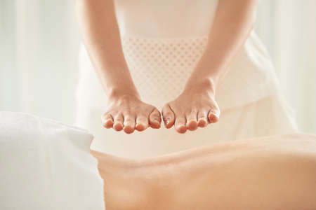 Hands of woman doing reiki healing treatment on female patientの写真素材