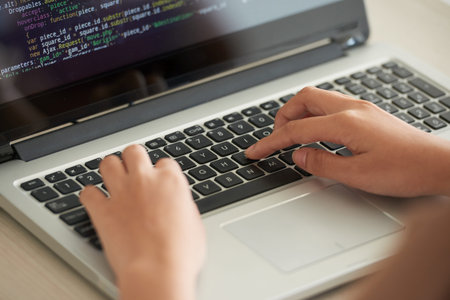 Programmer working on laptop in office and writing code