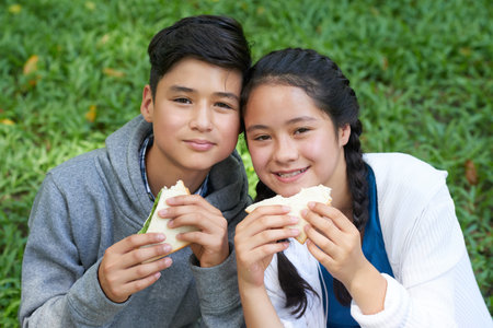 Twins eating sandwiches