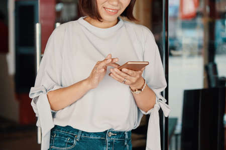Smiling woman checking smartphoneの写真素材