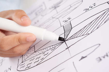 Closeup shot of hand of anonymous person using marker pen to draw business diagramの写真素材