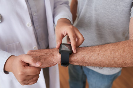 Faceless shot of doctor helping senior man with modern smart watch showing functionsの写真素材