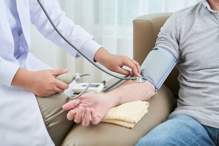 Crop shot of woman measuring blood pressure of senior man sitting in couch at home