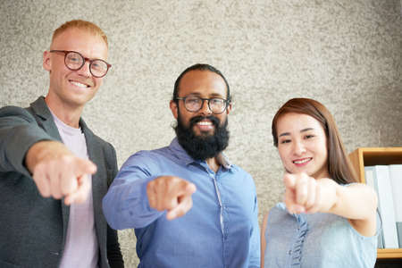 Portrait of successful young business team pointing at camera and smilingの写真素材