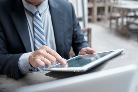 Close-up image of entrepreneur working with document on table computer