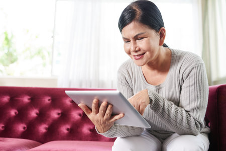 Positive senior woman with tablet computer