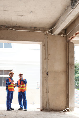 Workers discussing ceiling construction