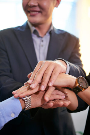 Business executives stacking hands before staring new ambitious project