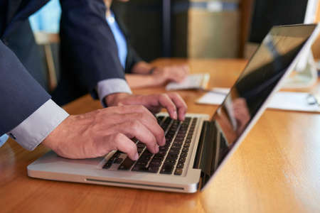 Hand of businessman working on laptop at table in meeting roomの写真素材
