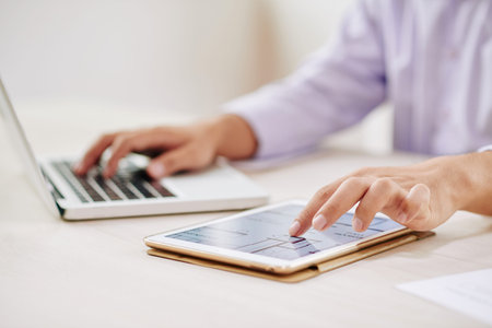Hand of contemporary office manager scrolling in touchpad while analyzing digital scheme and...