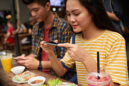 Girl photographing her dinnerの写真素材