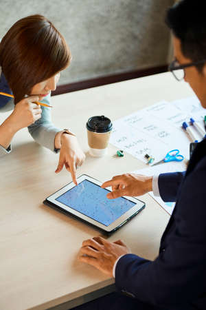 Asian business team analyzing statistics of company developmentの写真素材