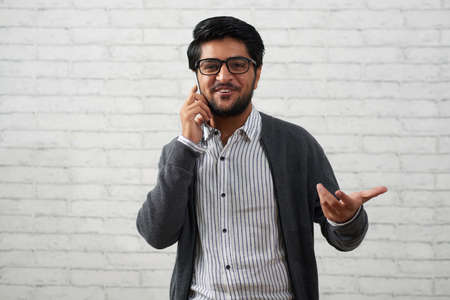 Positive young man talking on phoneの写真素材