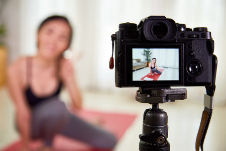 Beautiful young woman using photo camera for her sporty blog or she making a selfie portrait during...