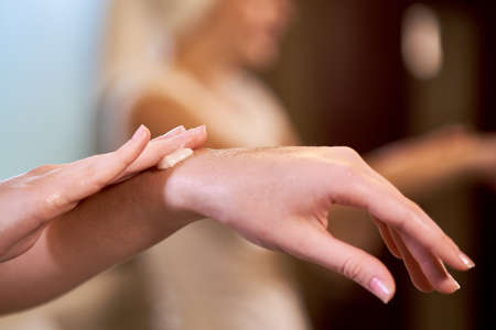 Close-up of woman applying moisturizing cream for her hands for protection and rejuvenationの写真素材