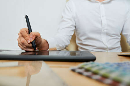 Close-up image on creative specialist using graphic tablet when drawingの写真素材