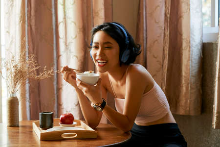 Happy woman eating breakfastの写真素材