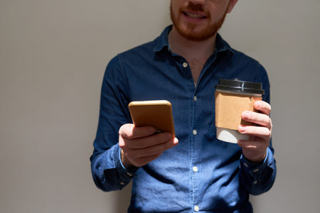 Texting man with coffee
