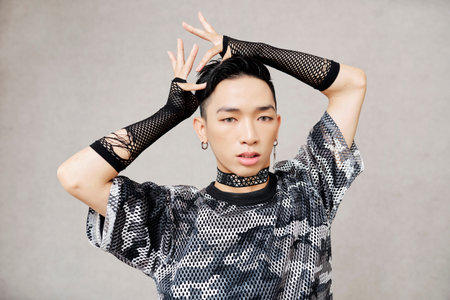 Handsome young Vietnamese man in stage costume dancing vogue dance