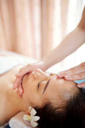 Specialist doing rejuvenating face massage with oils and serumの写真素材