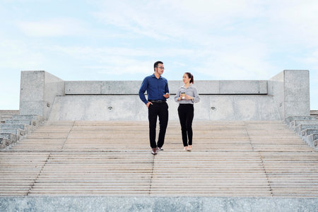 Vietnamese business people discussing various issues when walking down stairs