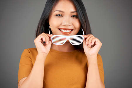 Portrait of young attractive Vietnamese woman wearing shutter glasses to add some spice to her lookの写真素材